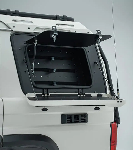 Open cargo area of a white vehicle with a black cover on a gray background